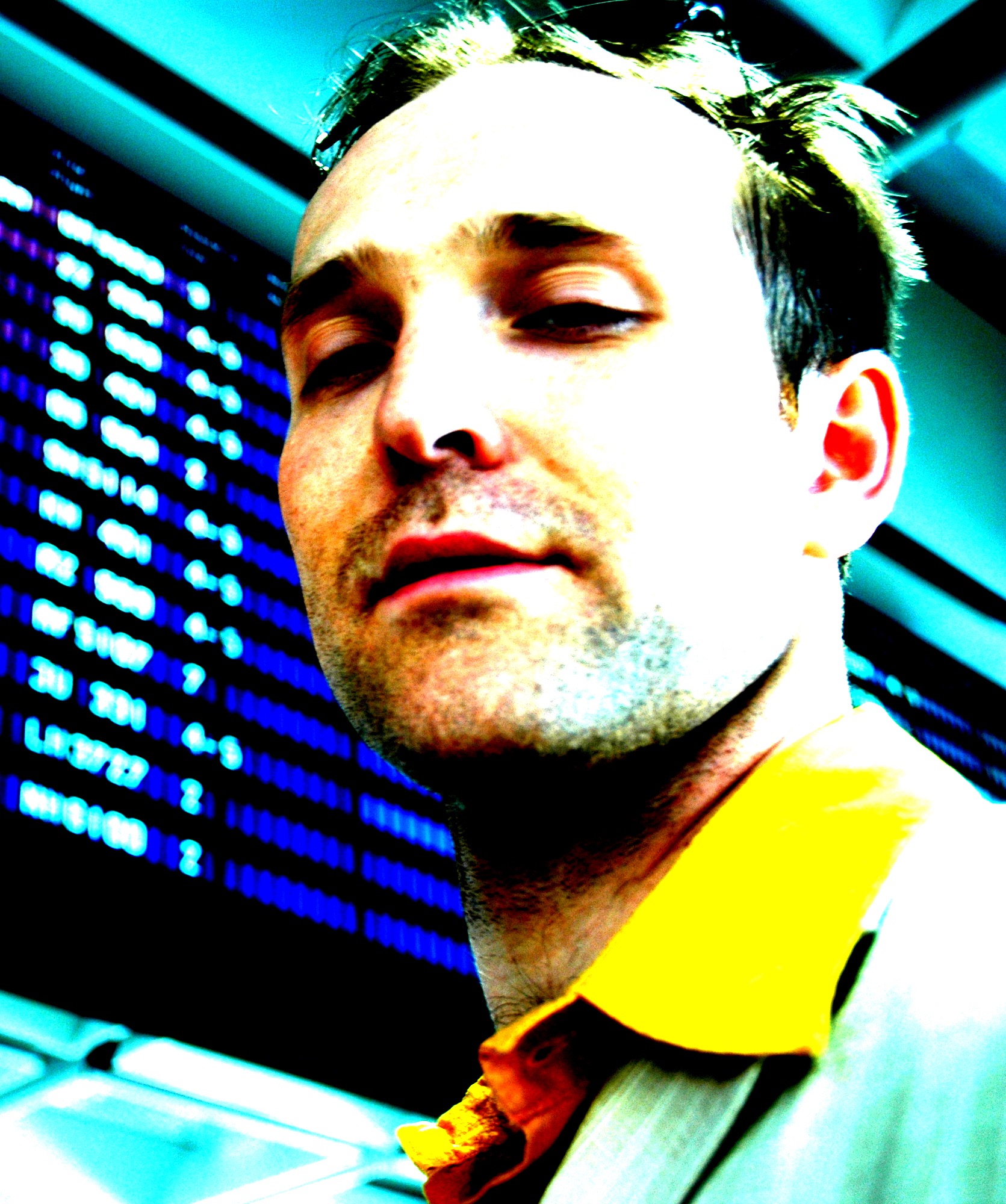 Colour saturated close portrait in front of a departure board