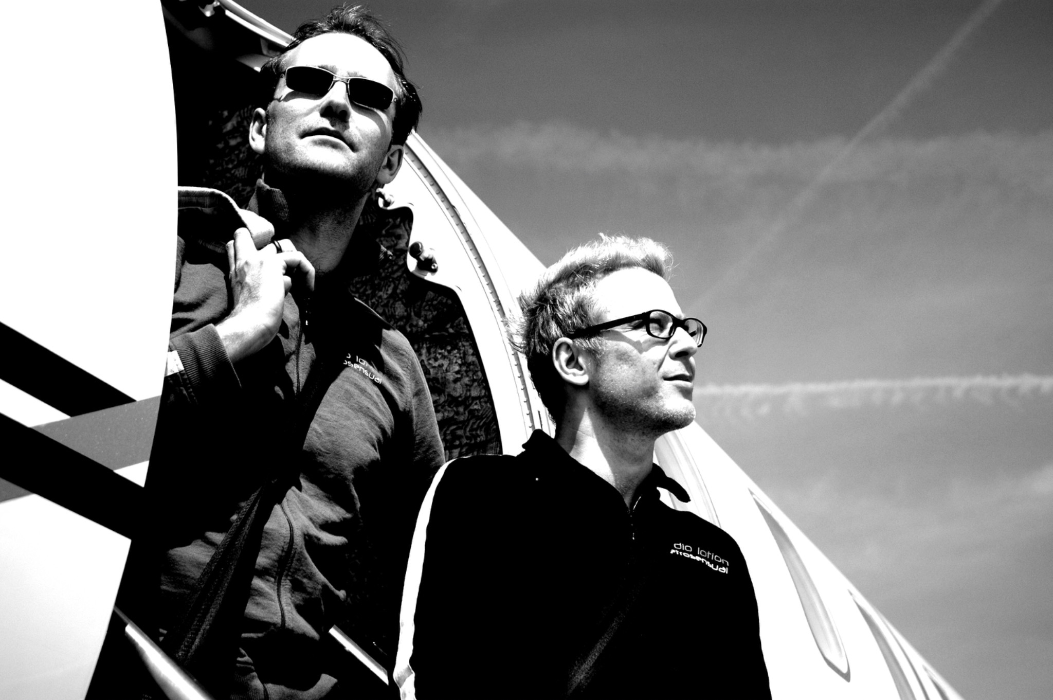 Black and white portrait of the two musicians beside the aircraft